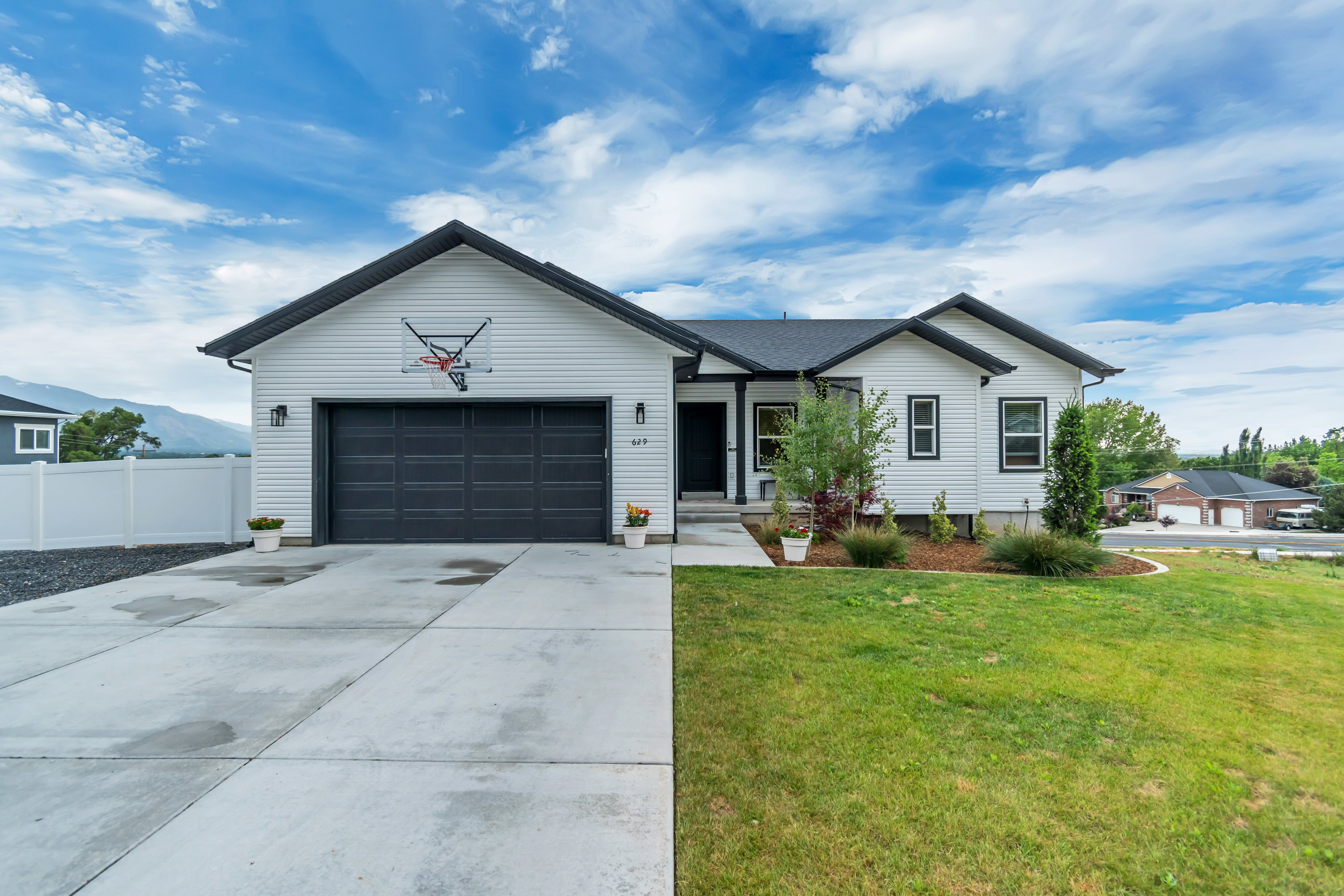 White siding exterior with black trim accents and a dark gray garage door