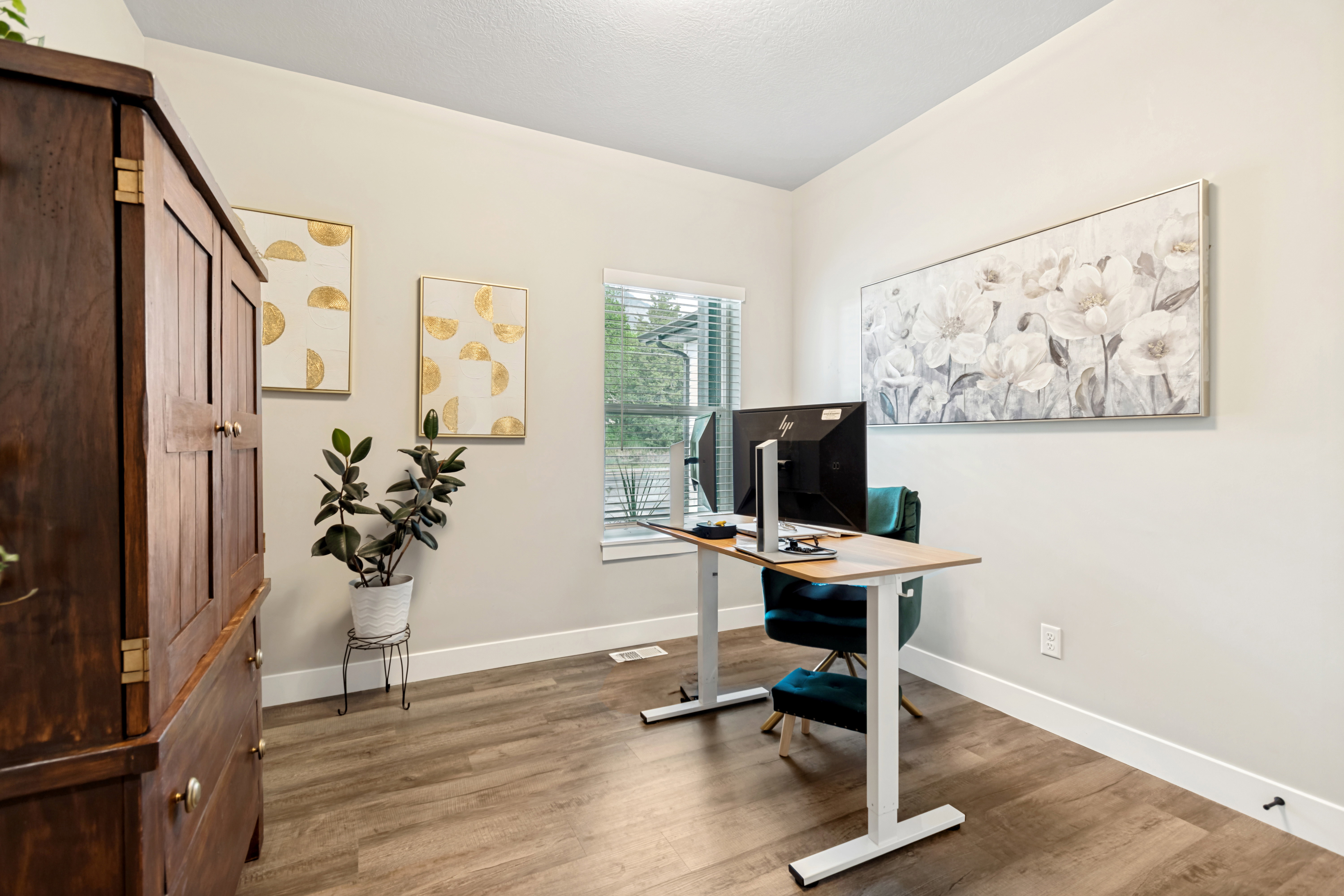 Bright room featuring wood-finish flooring, light-toned walls, and a window with blinds