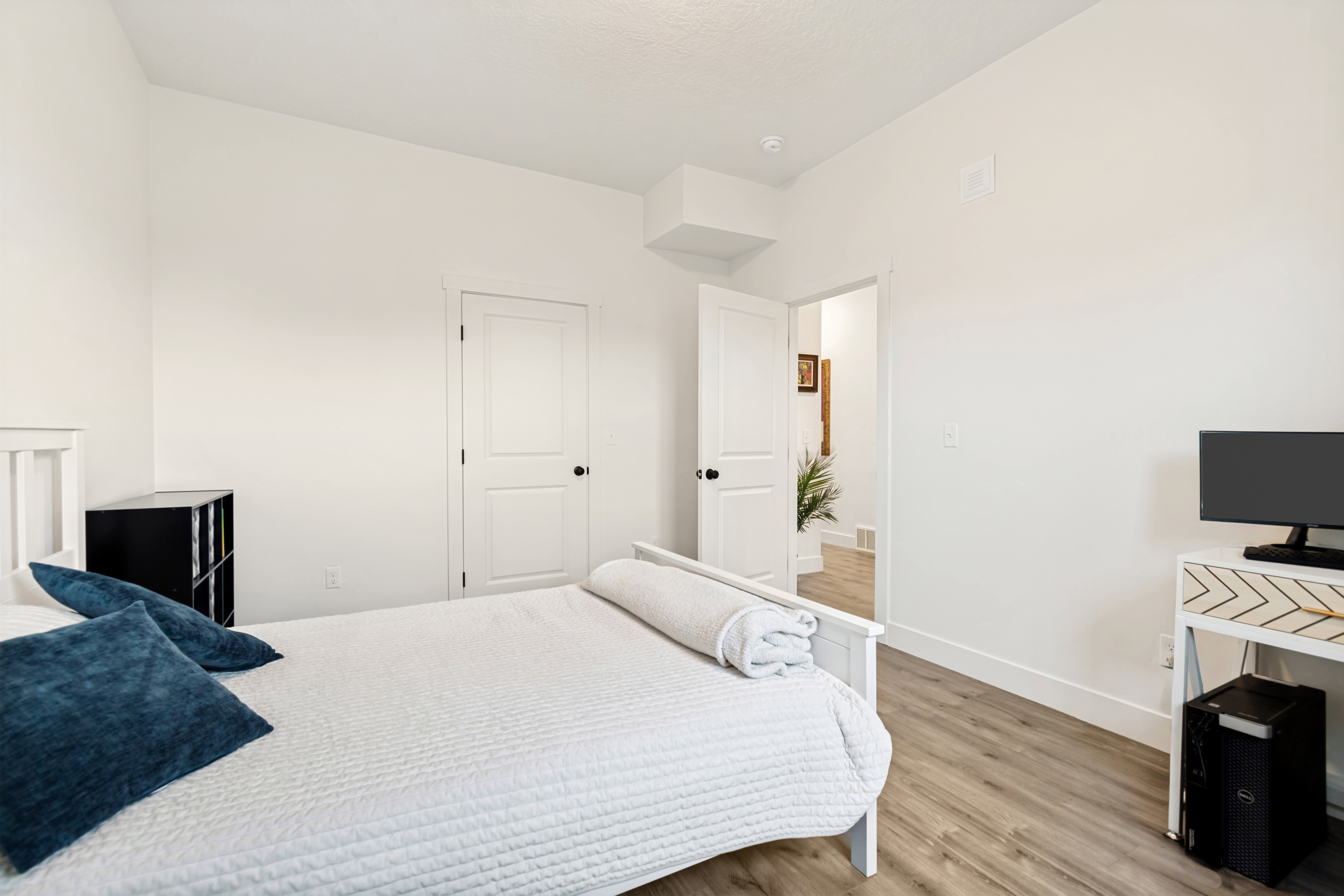 Room featuring wood-finish flooring, white baseboards, and bright white walls