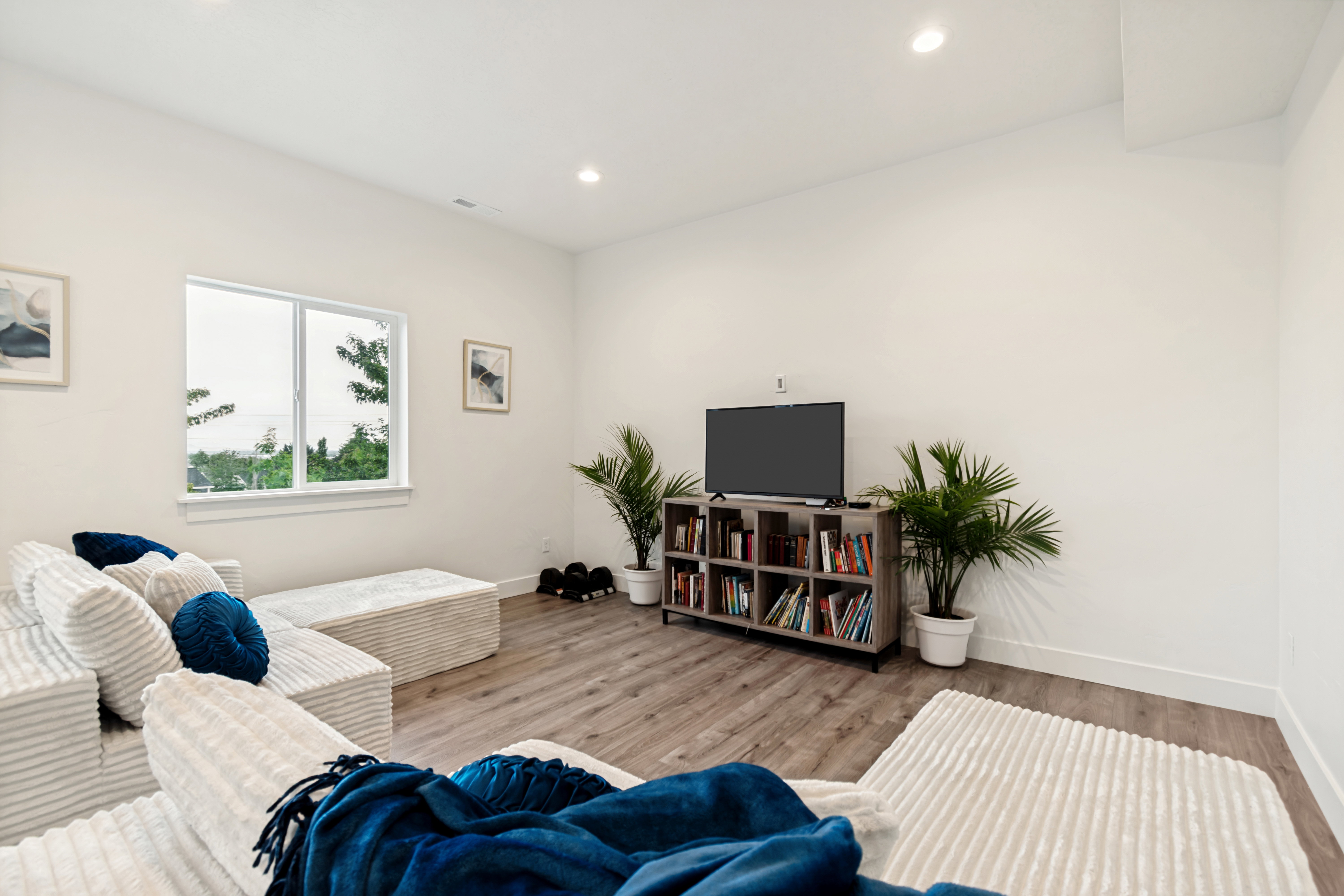 Spacious living area featuring light wood-finish flooring and recessed ceiling lighting