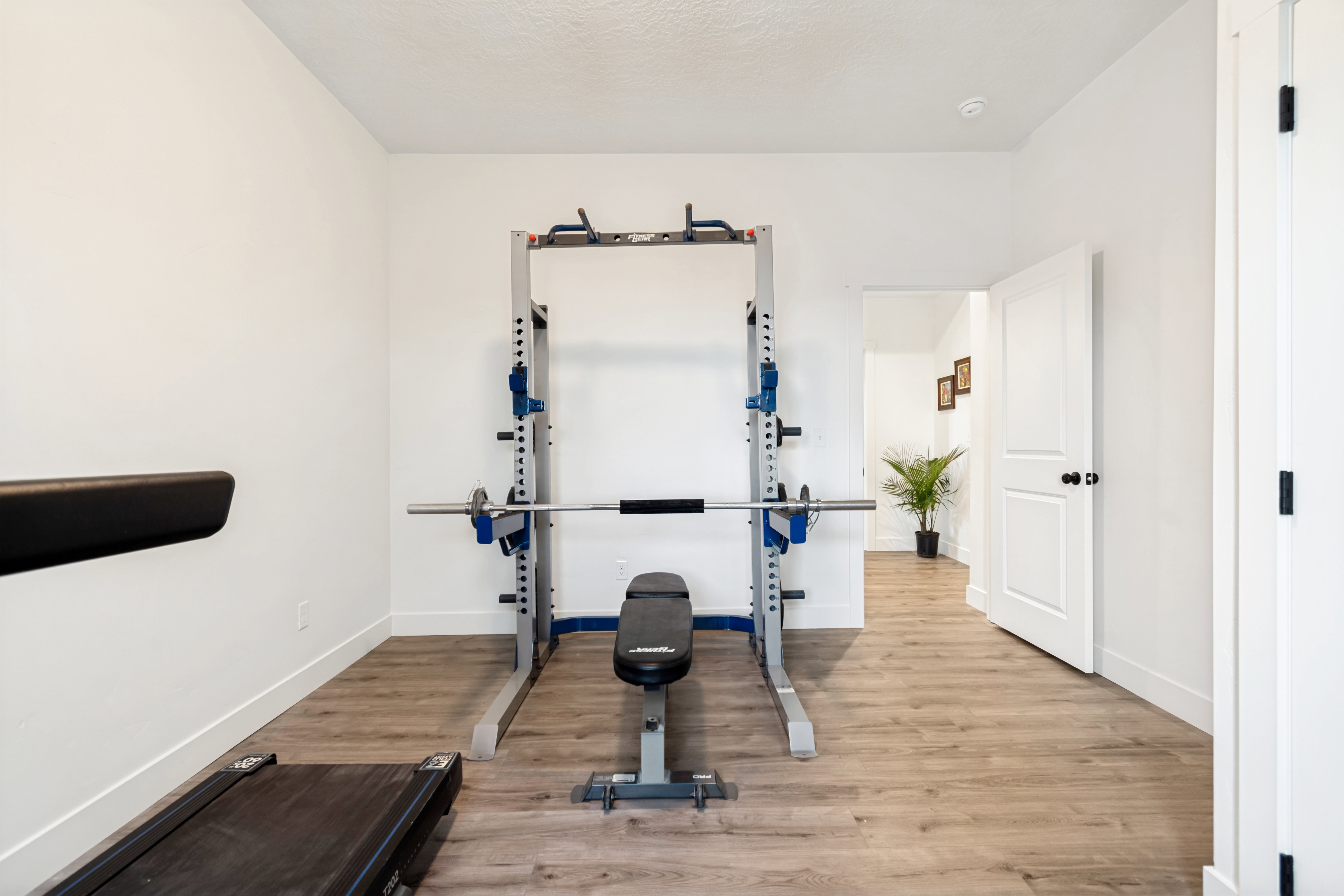Versatile room featuring light wood-finish flooring, white walls, and a white baseboard trim