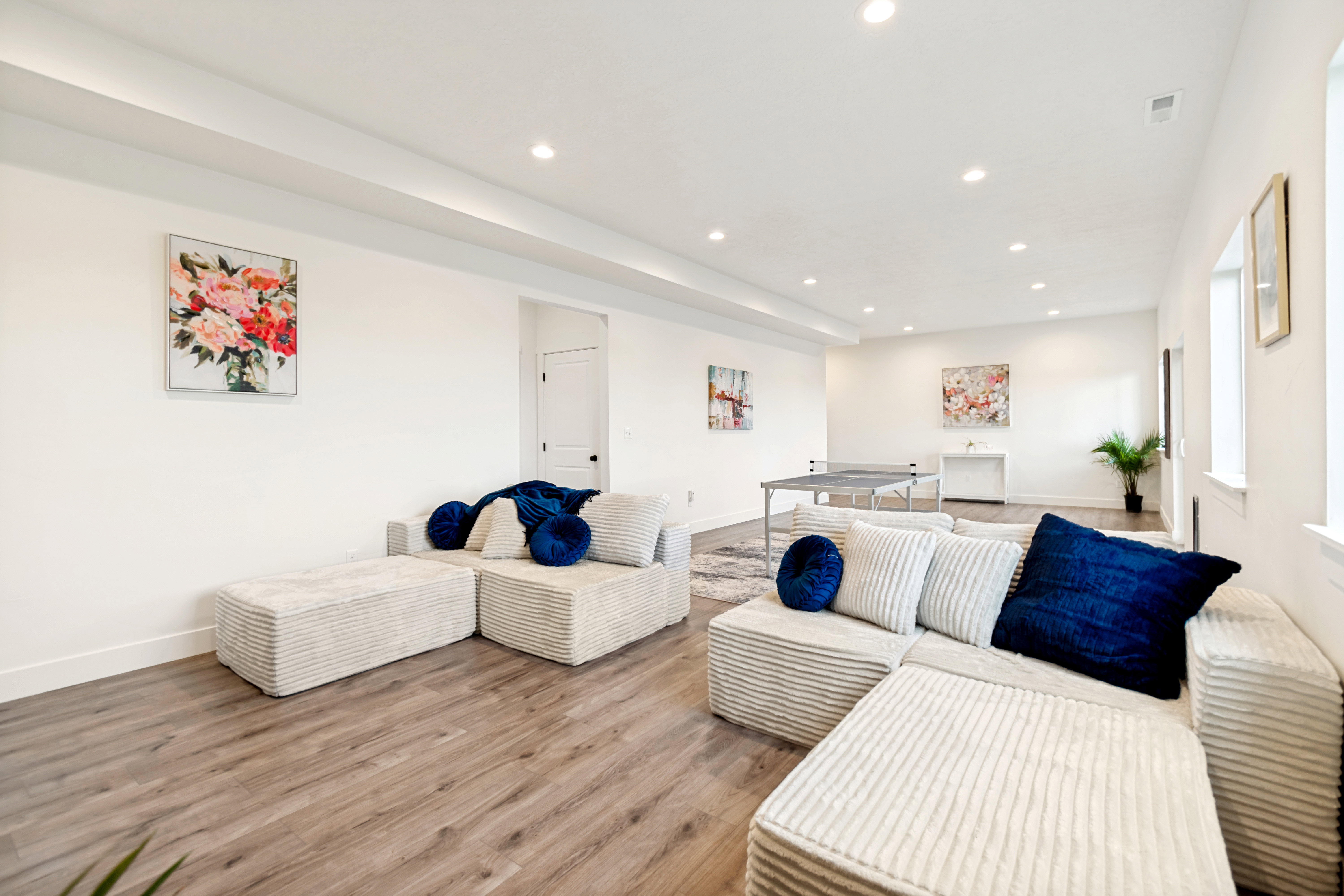 Spacious lower-level area featuring recessed lighting, wood-finish flooring, and multiple windows