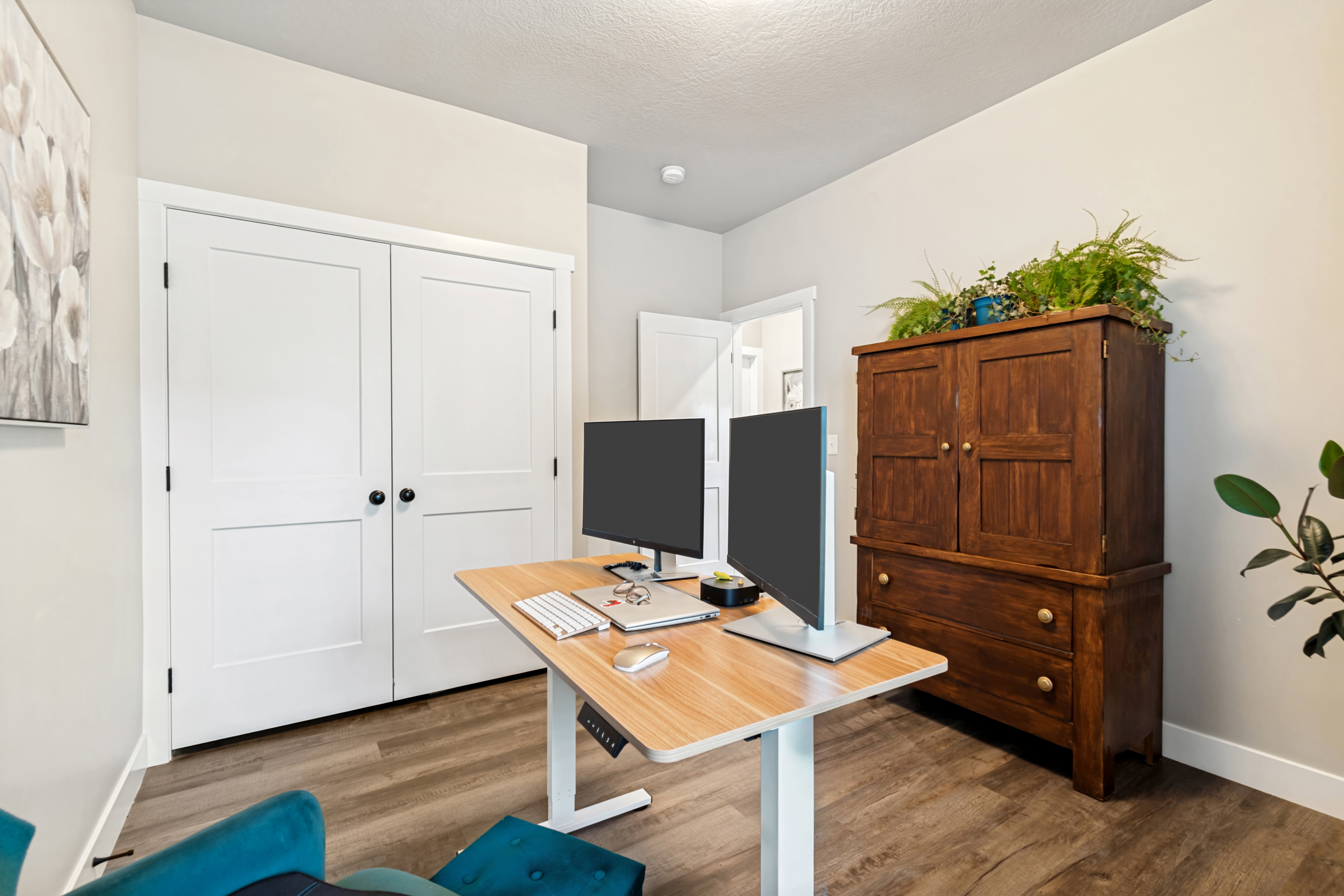 Interior room featuring wood-finish flooring, light neutral-toned walls, and white trim