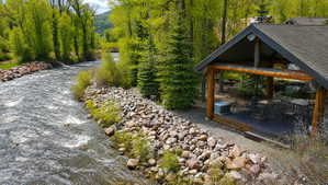 Riverfront outdoor pavilion featuring a gabled roof and exposed log beams