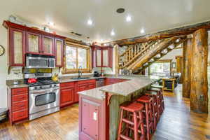 Kitchen featuring red cabinetry, stainless steel appliances, and granite countertops