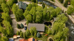 Riverside property featuring a main residence, an additional dwelling, mature trees, and a circular water feature