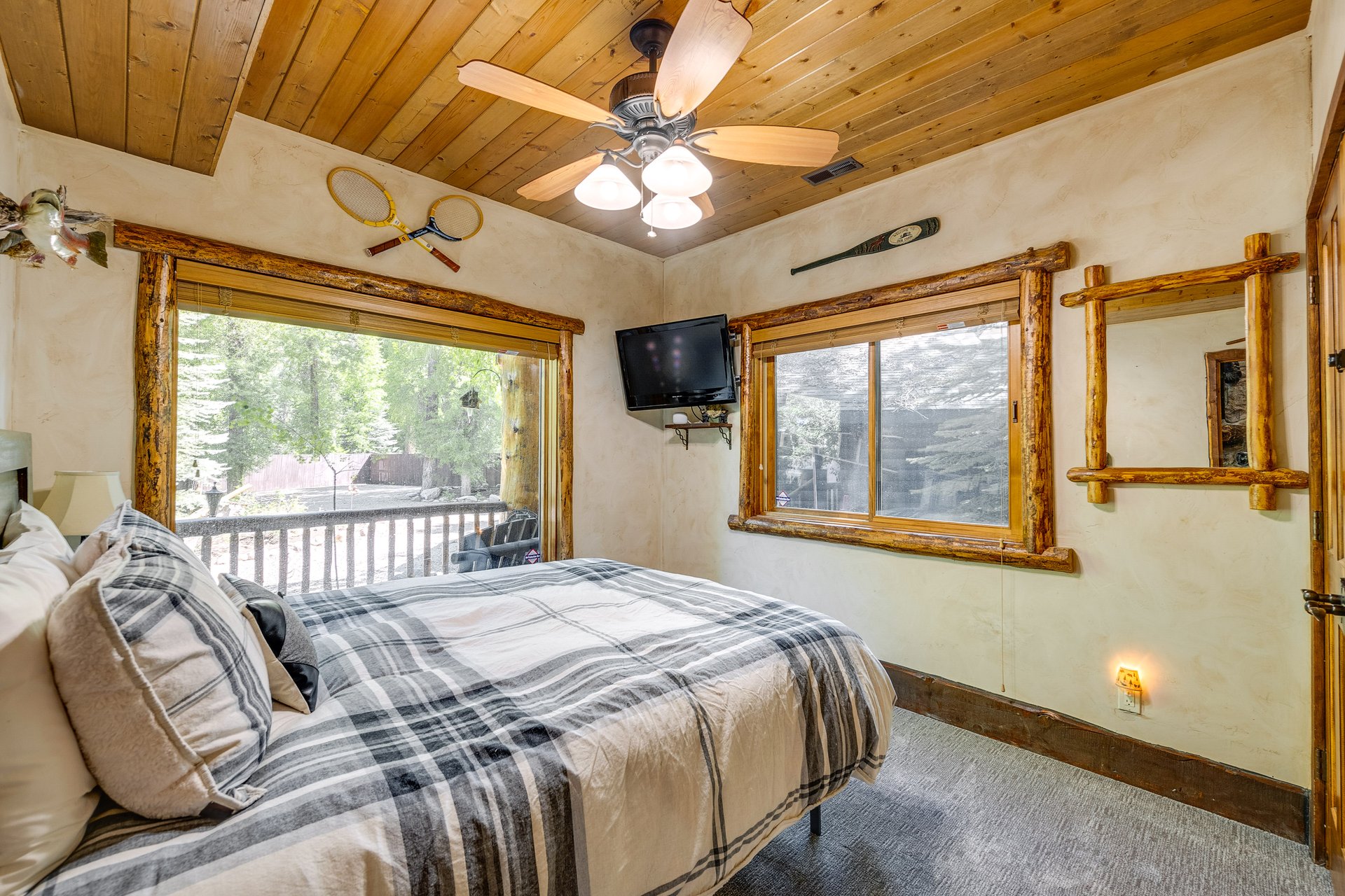 Bedroom featuring a wood-paneled ceiling, ceiling fan, and wood-trim windows