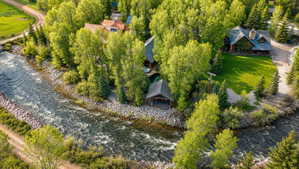 Riverside property featuring a main residence, a guest residence, and a covered pavilion structure