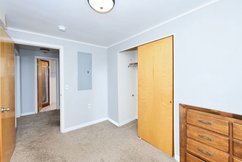 Bedroom featuring light gray walls, brown carpet flooring, and a flush mount ceiling light