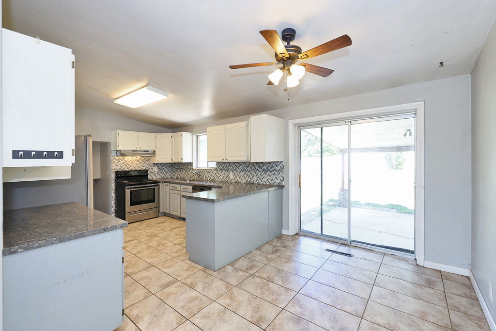 Kitchen featuring tile flooring, light cabinetry, and patterned backsplash