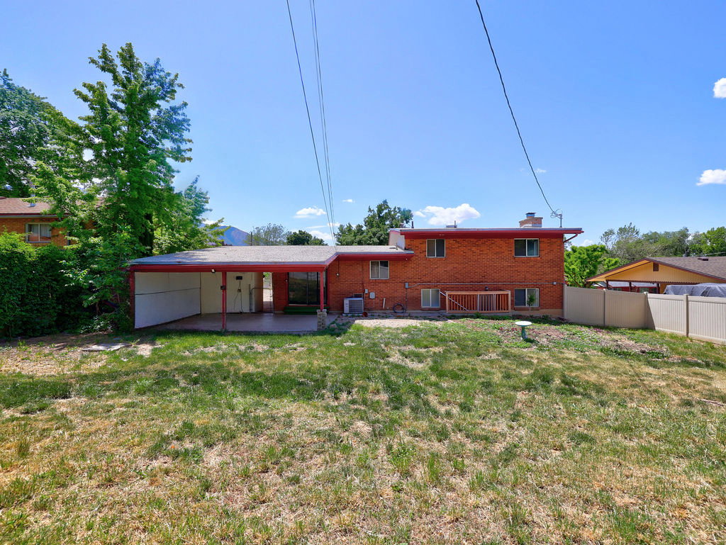 Brick exterior featuring a covered patio and an extended carport