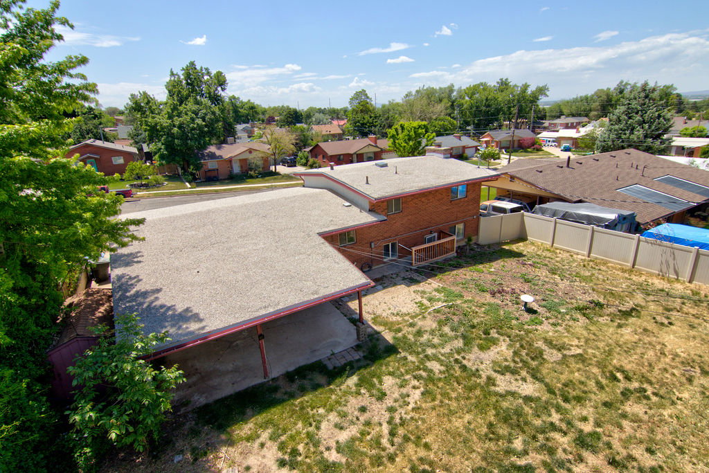 Rear exterior featuring a brick facade, covered patio, and a second-story deck