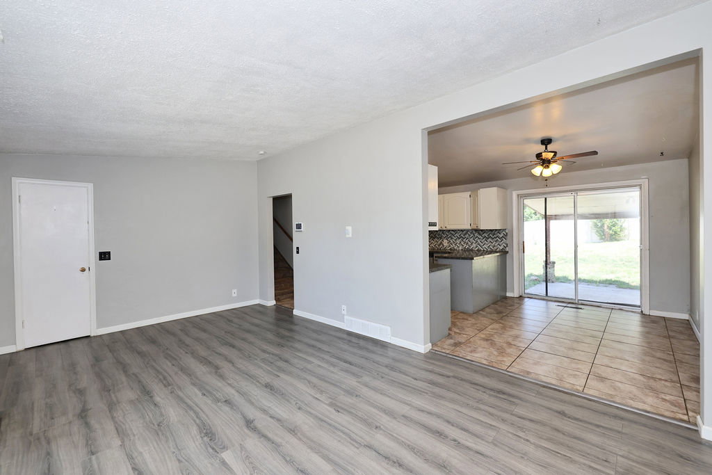 Open-concept living area featuring wood-finish flooring, light gray walls, and white baseboards