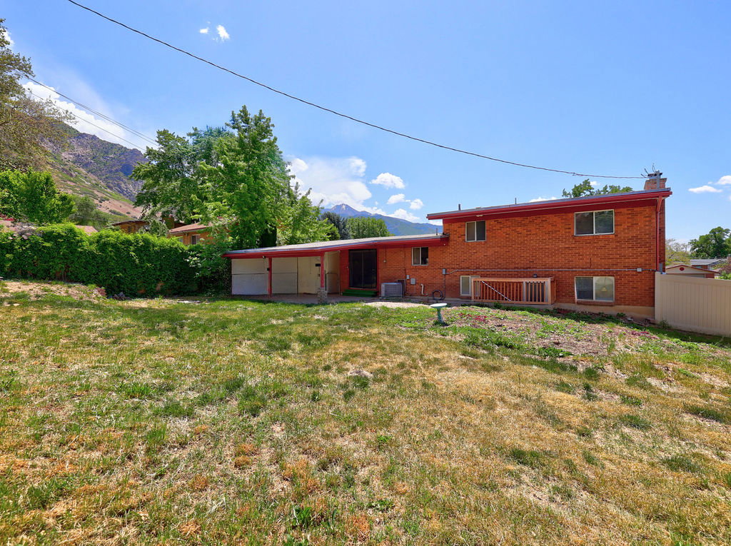 Expansive backyard with a sloped lawn and mountain backdrop