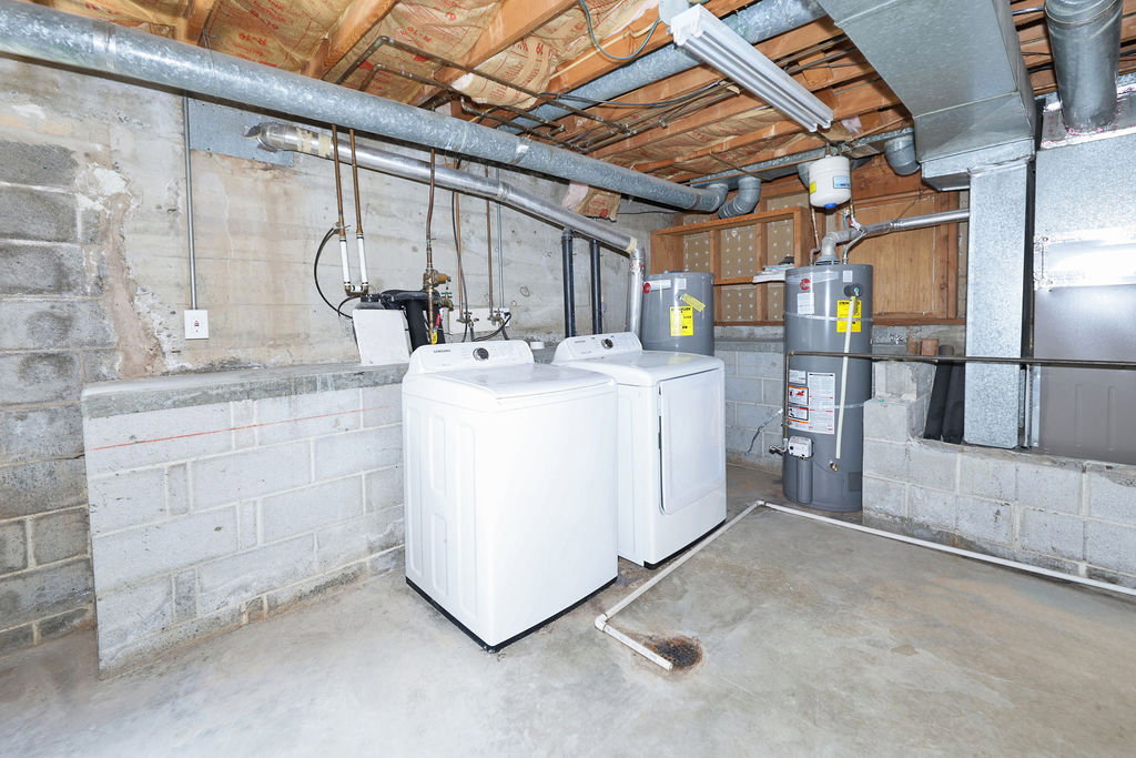 Utility area featuring concrete block walls and a concrete floor