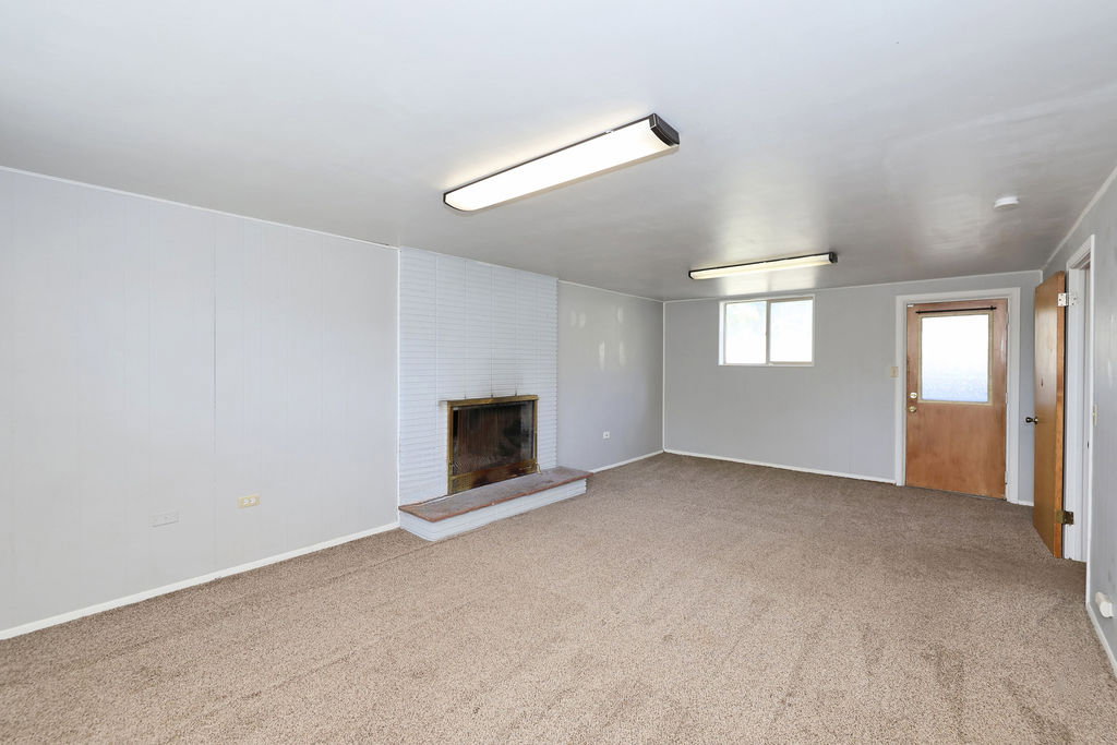 Spacious room featuring neutral carpeting and light gray walls