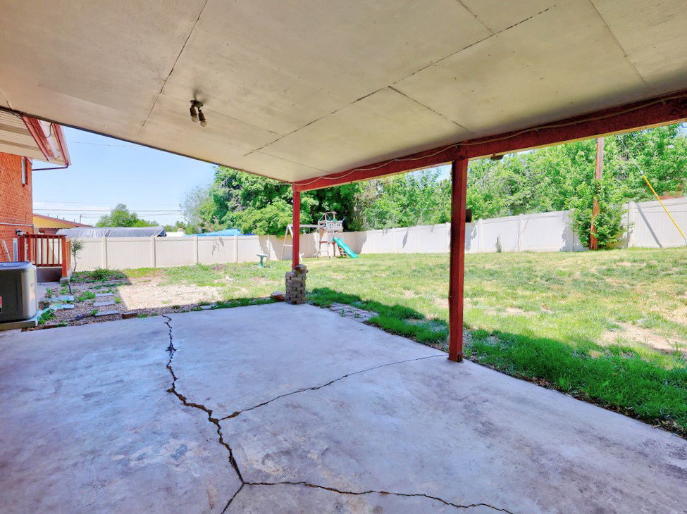 Covered patio space featuring a concrete slab and exposed support beams