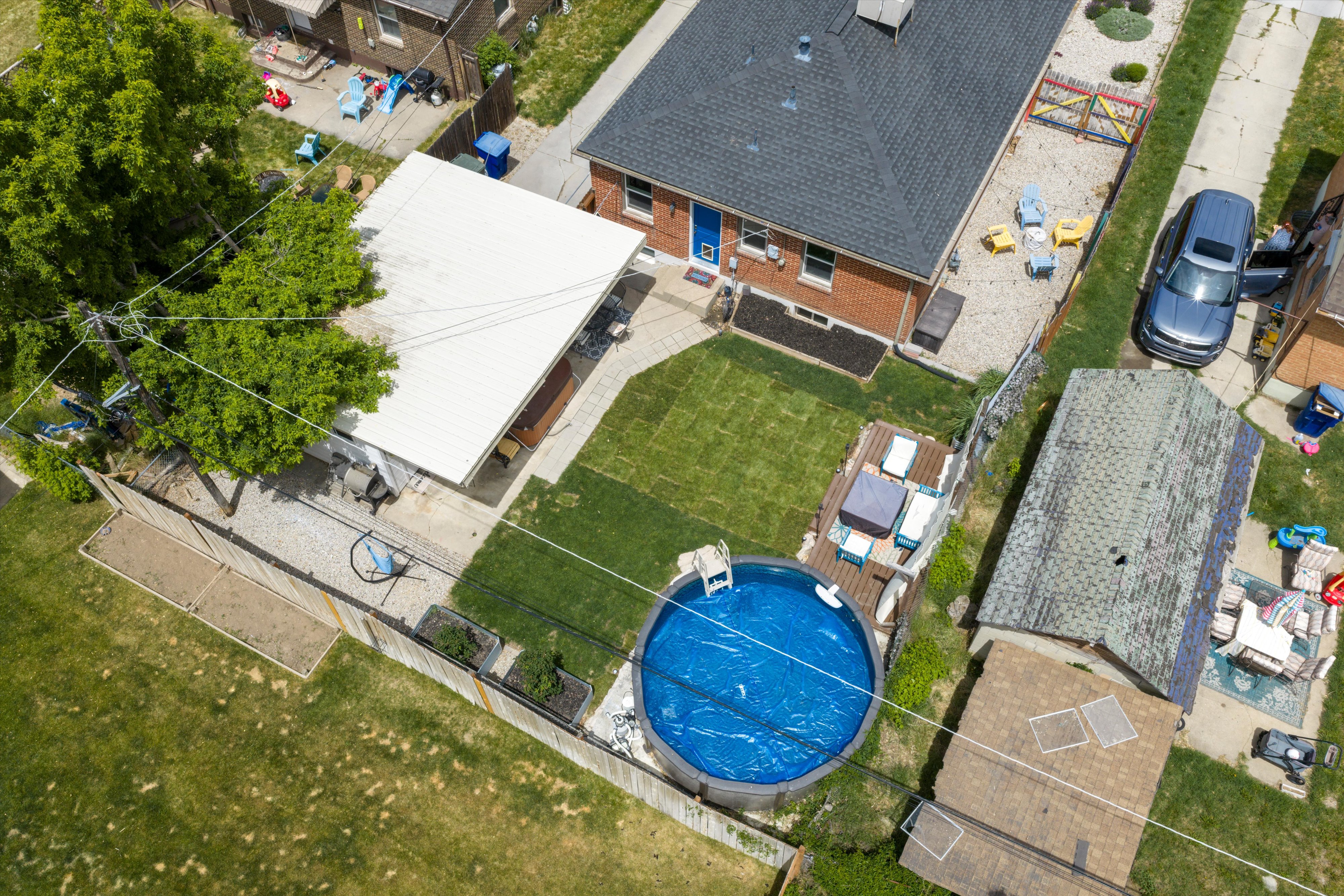 Brick exterior featuring a dark shingle roof, a dedicated pool deck, and a circular above-ground pool