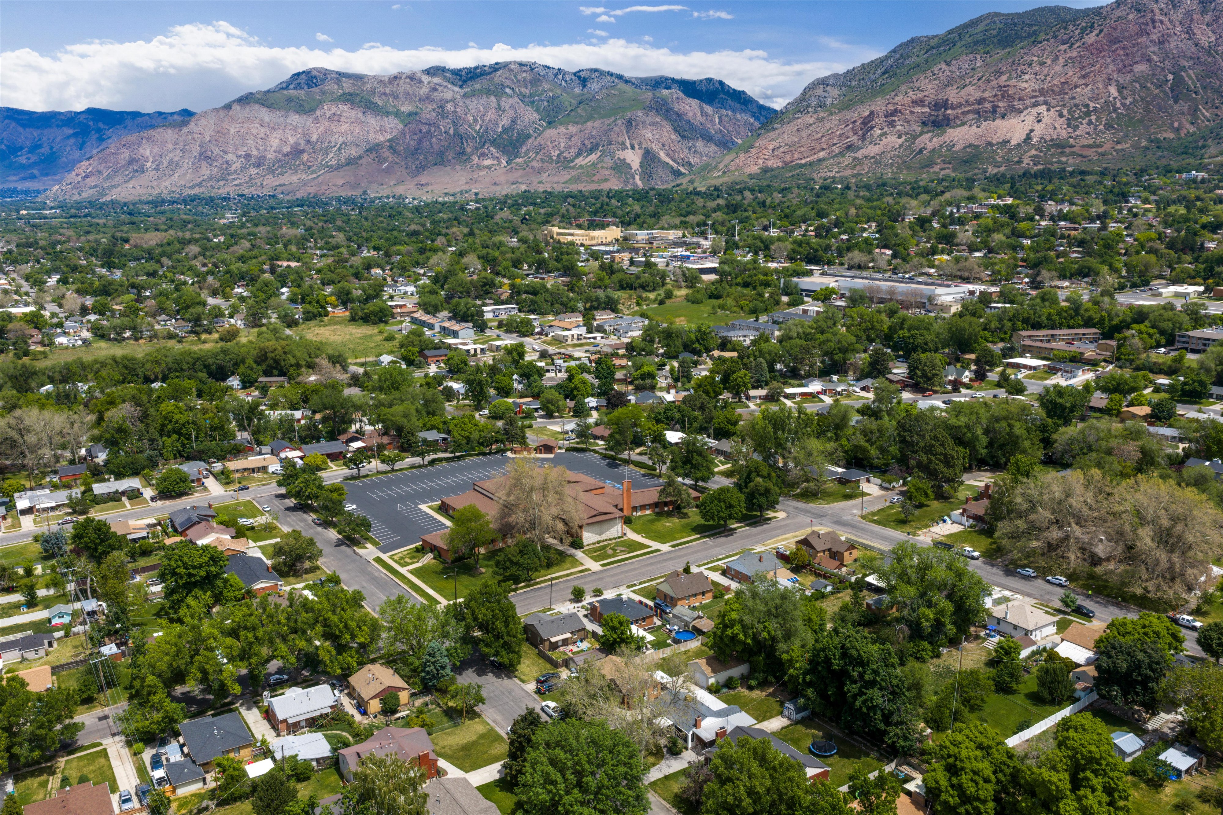 Expansive neighborhood featuring mature tree canopy, residential streets, and distant mountain ranges