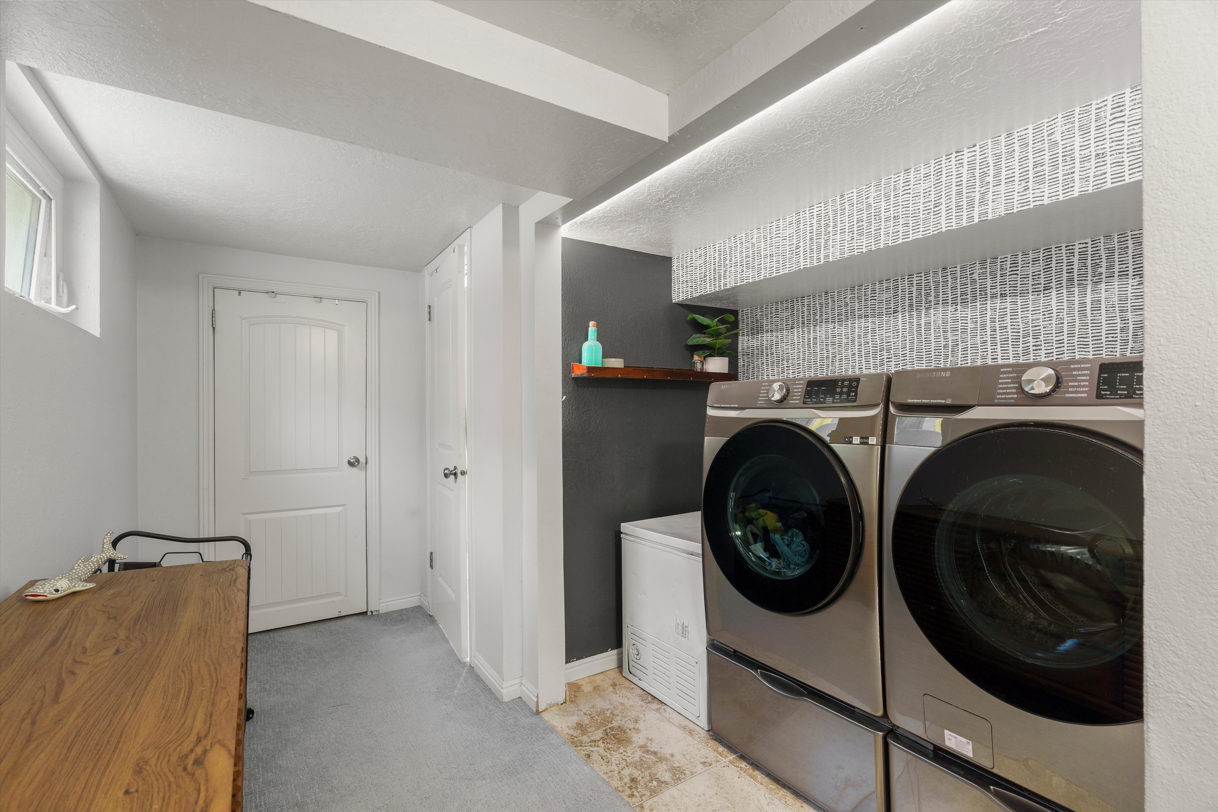 Dedicated laundry area featuring modern front-loading washer and dryer units
