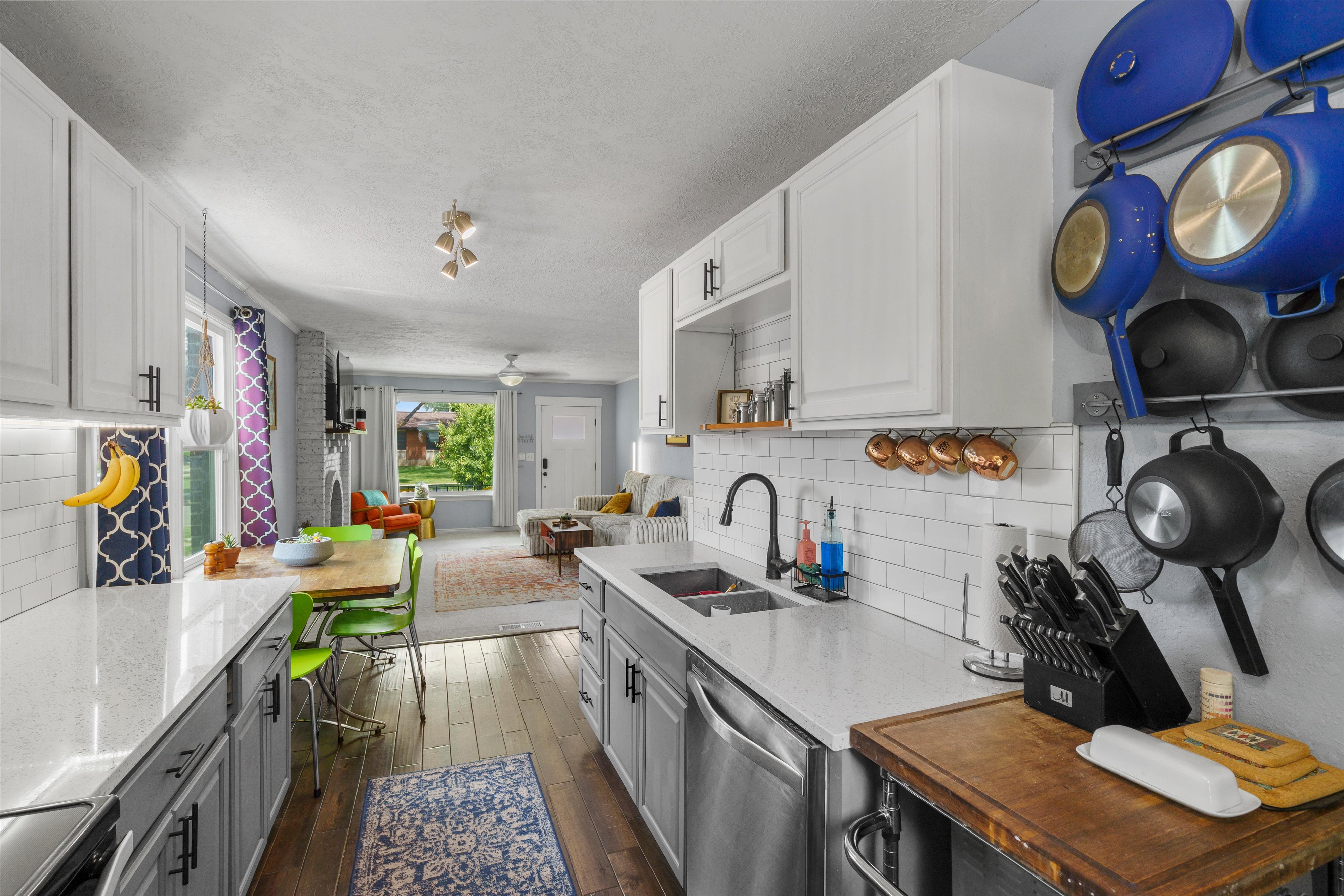 Contemporary kitchen featuring light-toned cabinetry, quartz countertops, subway tile backsplash, and stainless steel appliances
