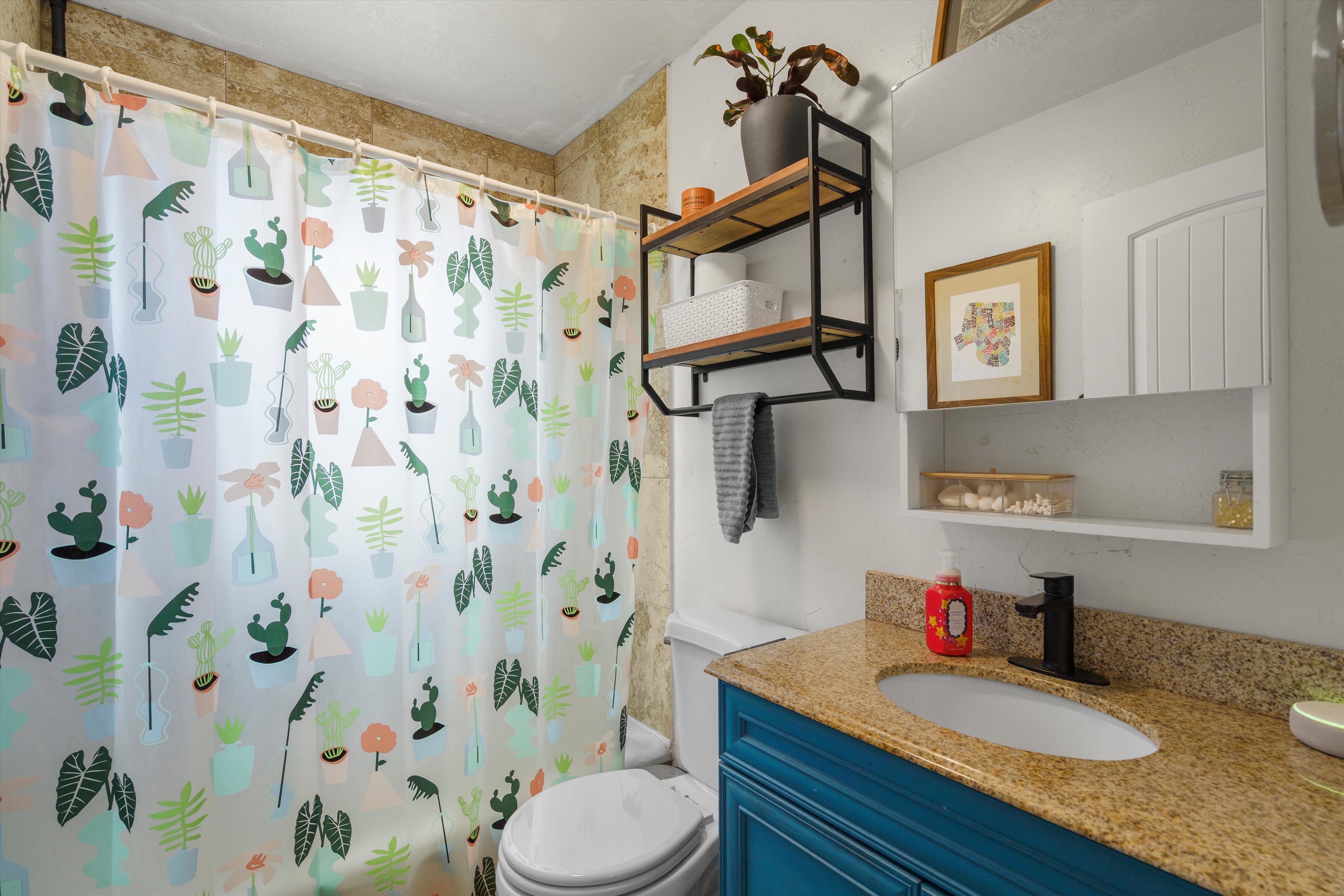 Bathroom featuring a vanity with a blue base cabinet, granite-finish countertop, and a black faucet