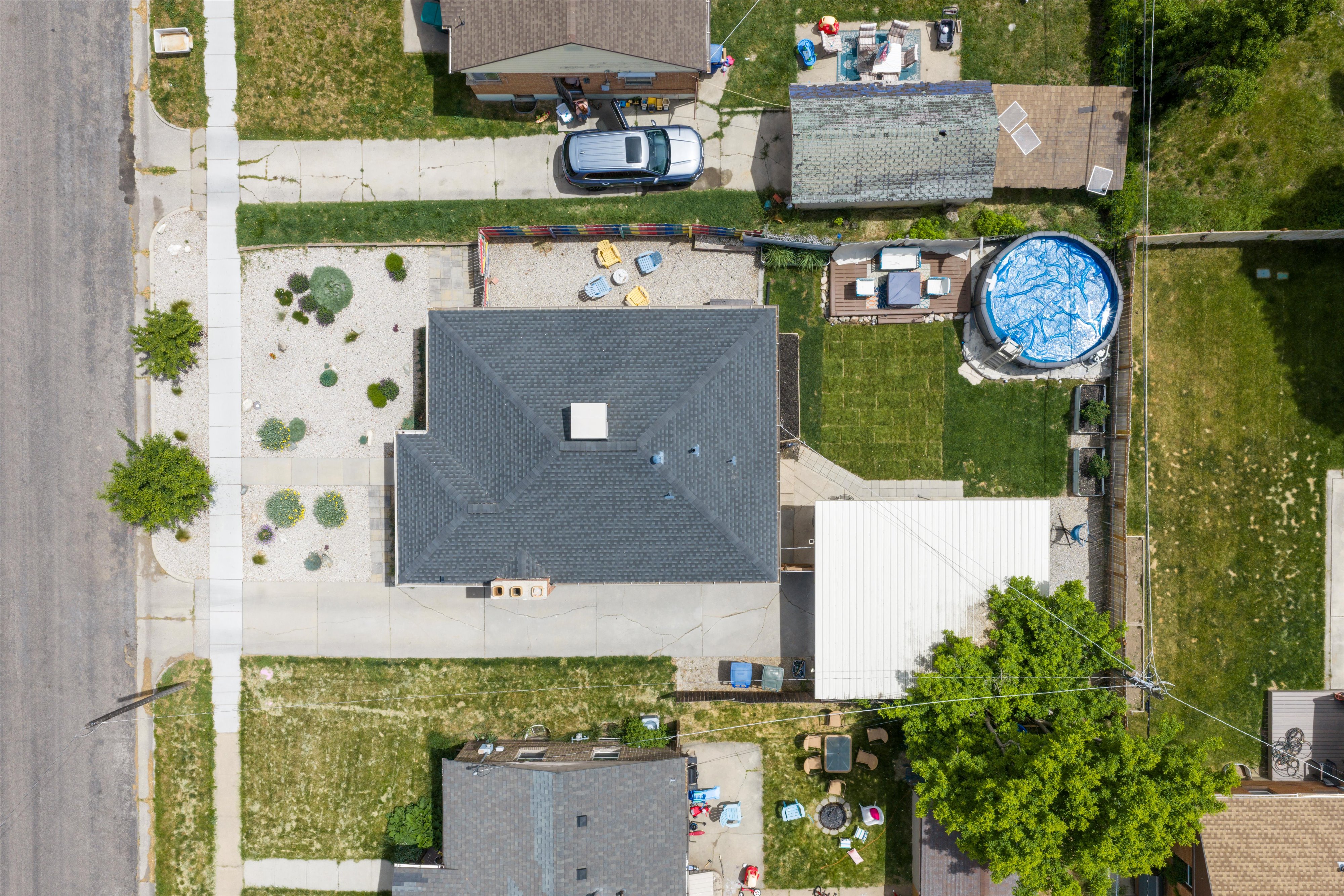 Property featuring a dark shingle roof, a front yard with xeriscaping, and a paved driveway