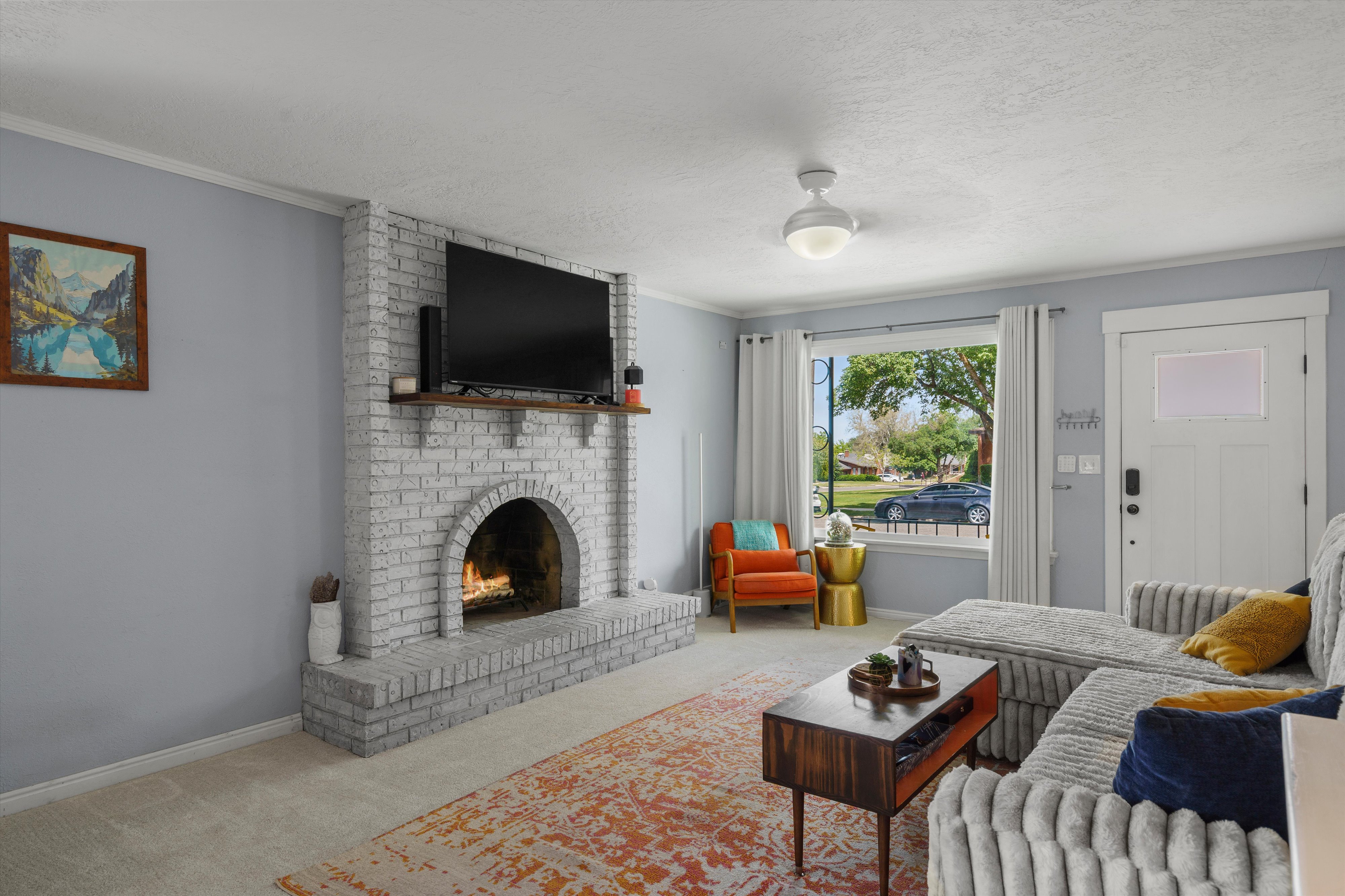 Living area featuring a painted brick fireplace with a wood mantel