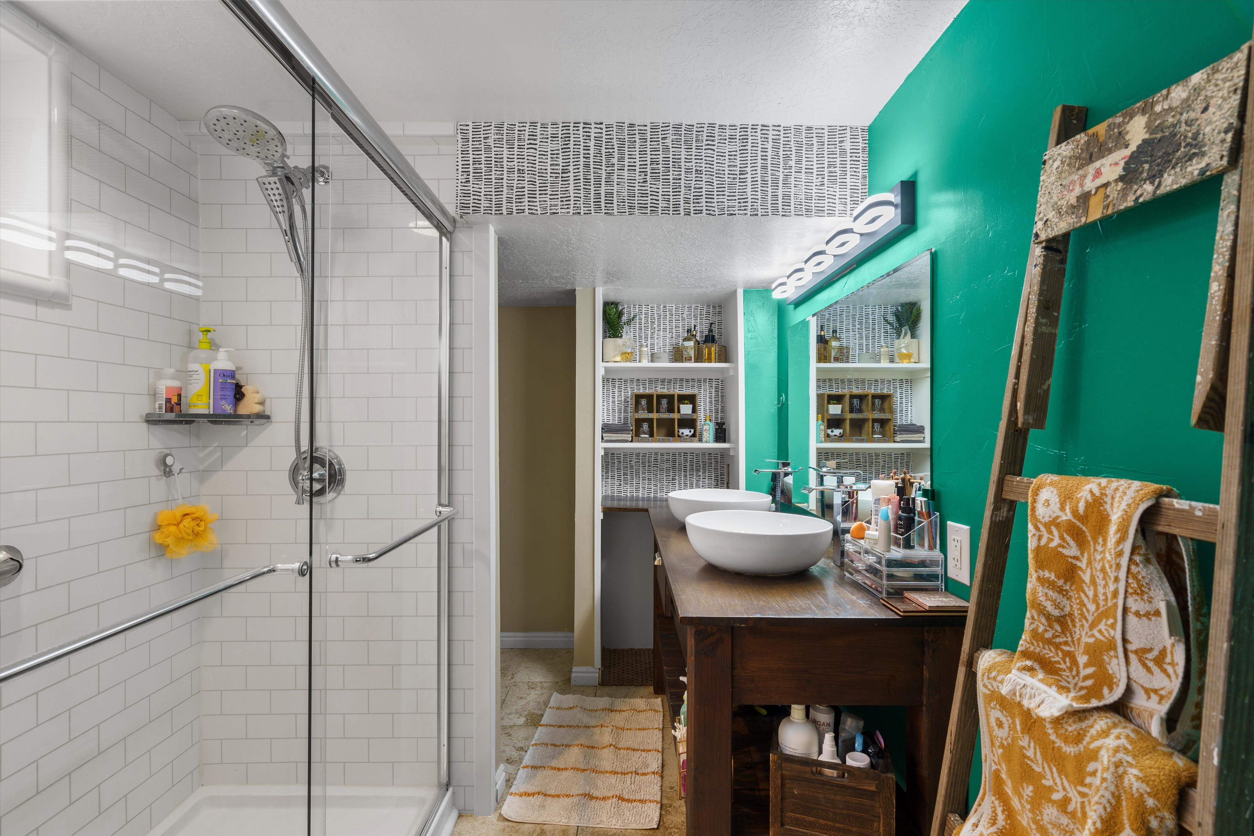 Bathroom featuring a walk-in shower with subway tile surround and glass enclosure