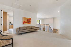 Carpeted upper level with recessed lighting and a white ceiling
