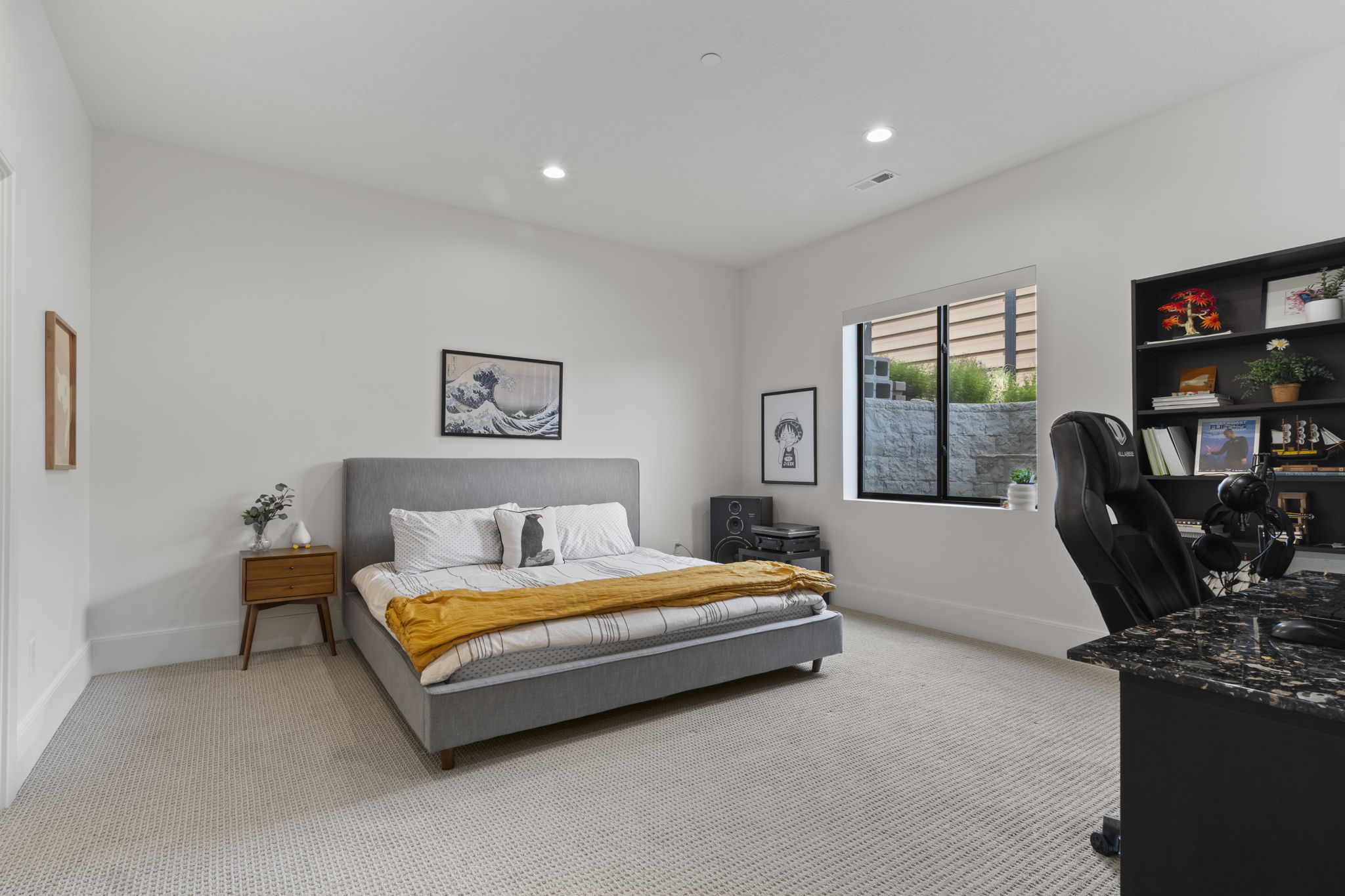 Spacious room featuring light-colored carpeting, recessed lighting, and a built-in shelving unit
