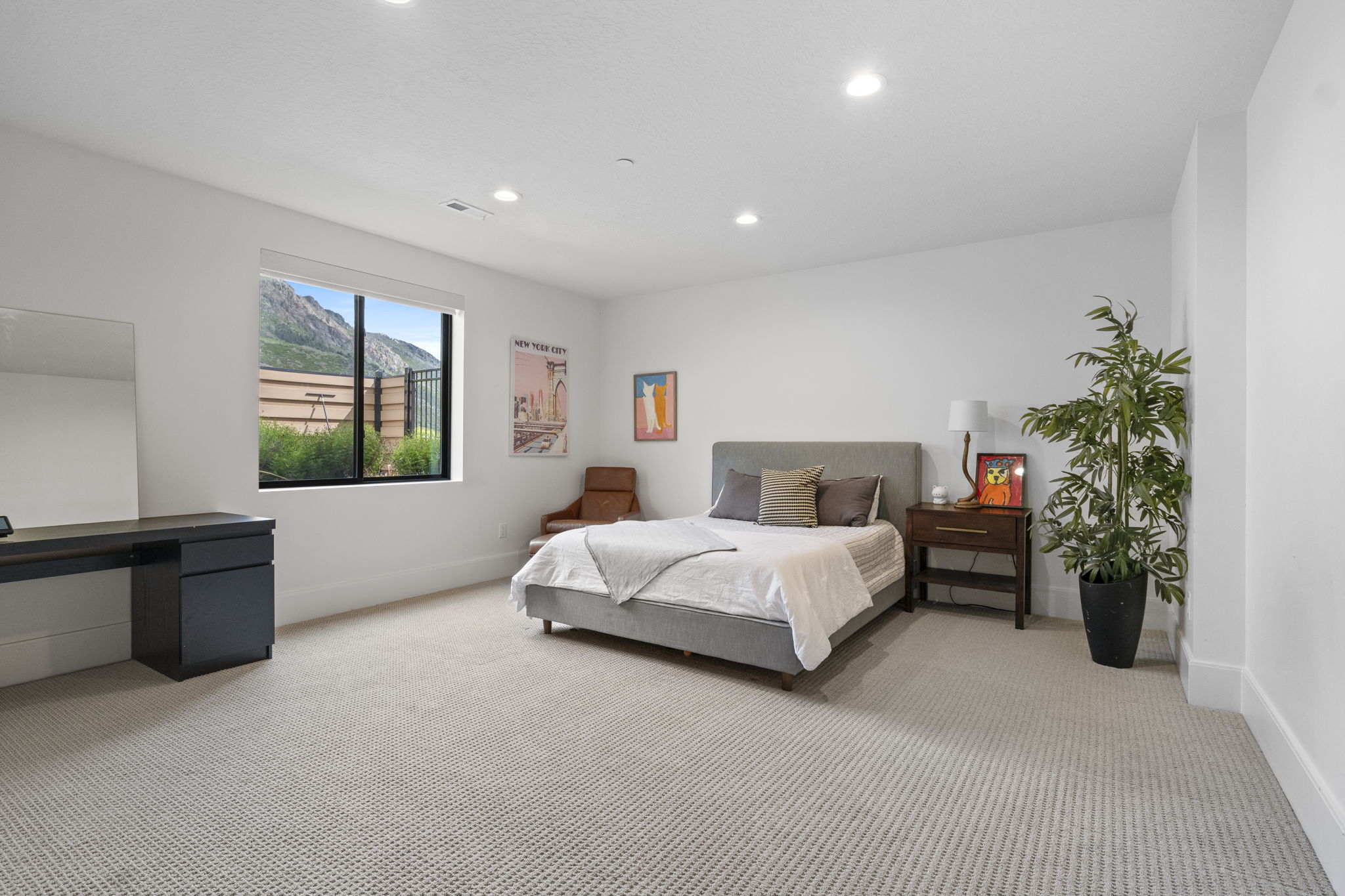 Spacious room featuring a large window, recessed lighting, and light-colored carpeting