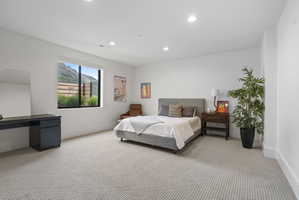 Spacious room featuring a large window, recessed lighting, and light-colored carpeting