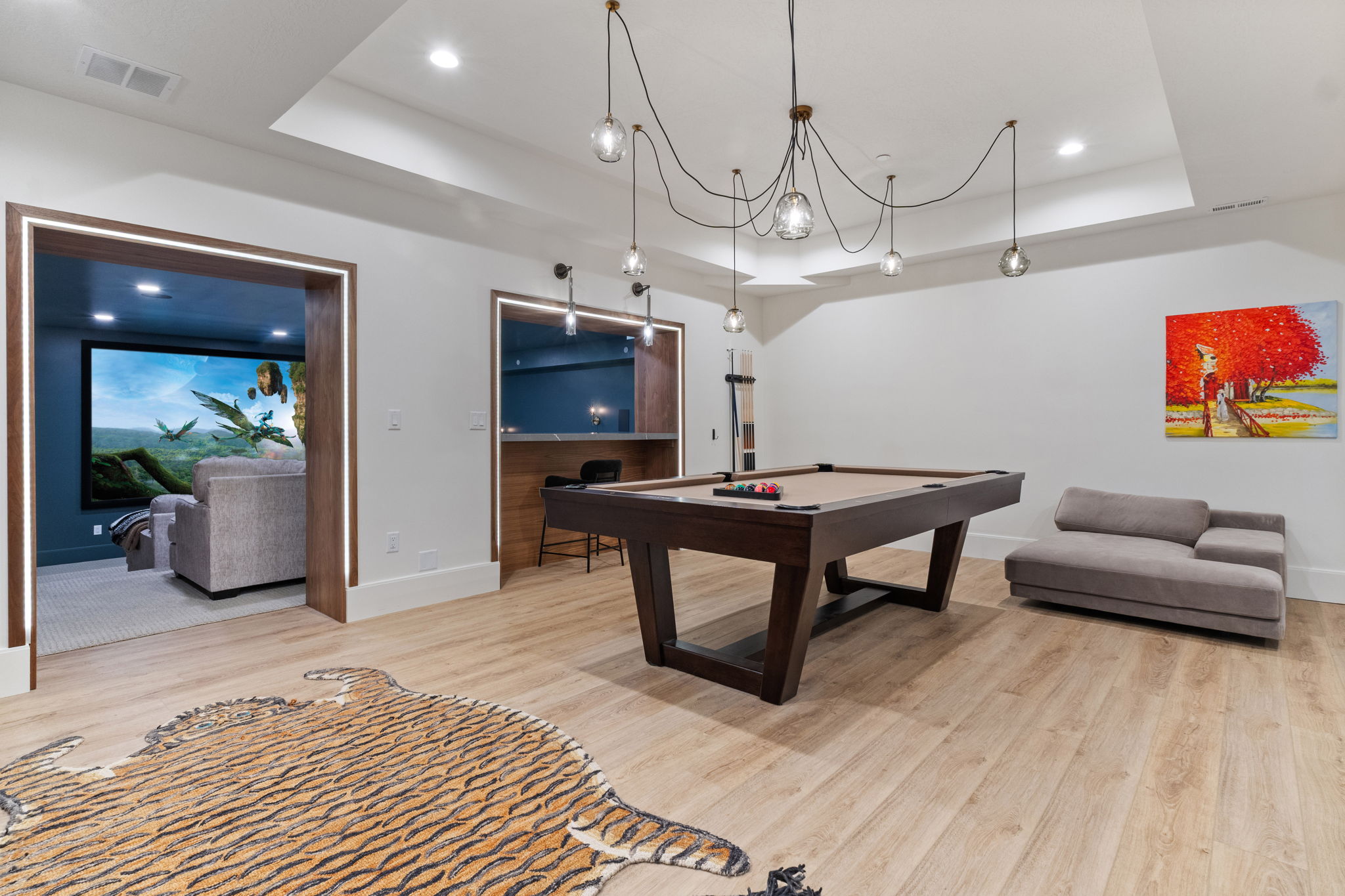 Recreational space featuring wood-finish flooring, a contemporary billiard table, and a built-in wet bar with integrated lighting