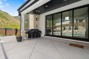 Expansive concrete patio featuring a built-in outdoor kitchen with stone detailing