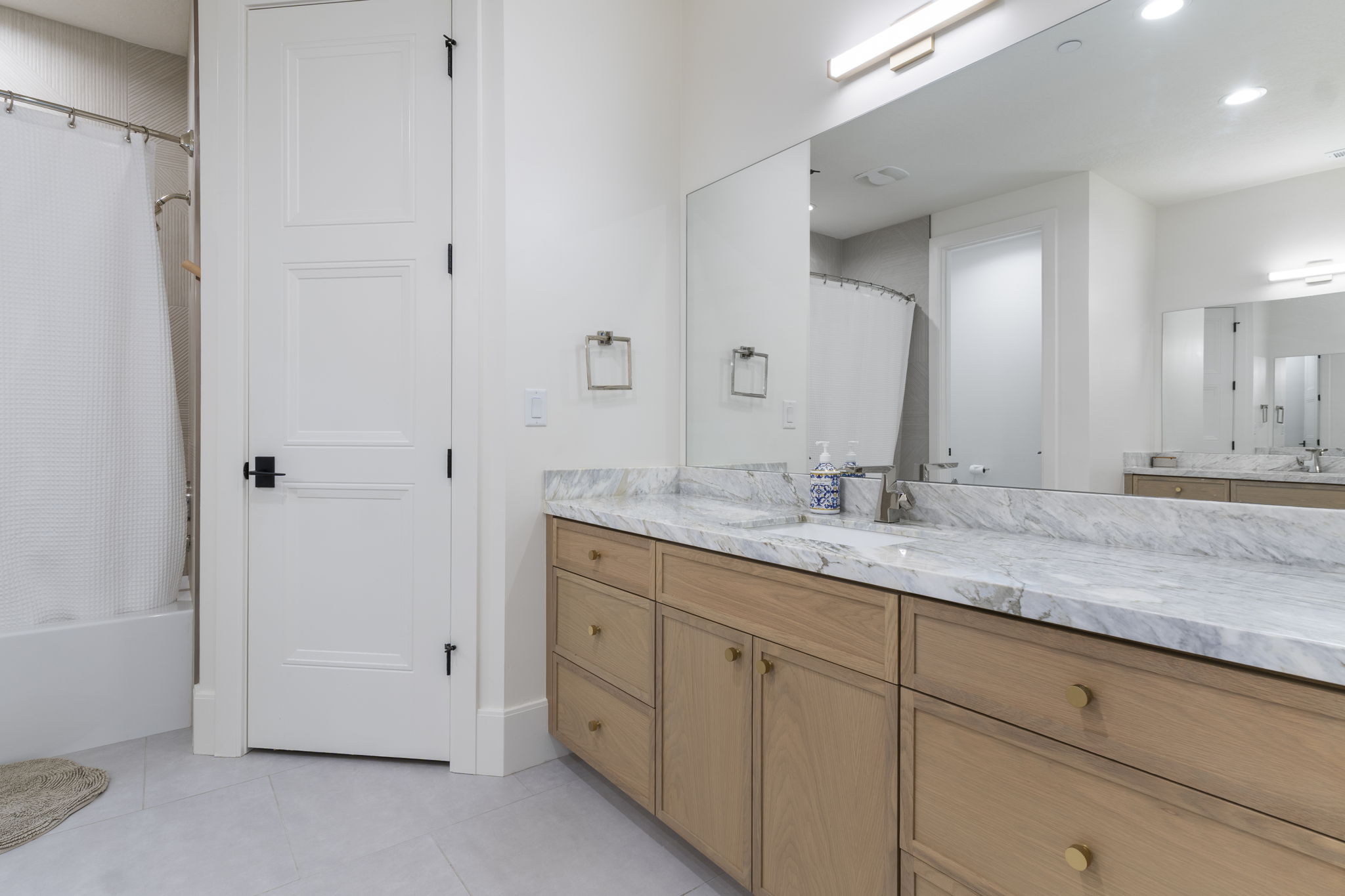 Double vanity with natural wood cabinetry and gold-tone hardware