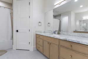 Double vanity with natural wood cabinetry and gold-tone hardware