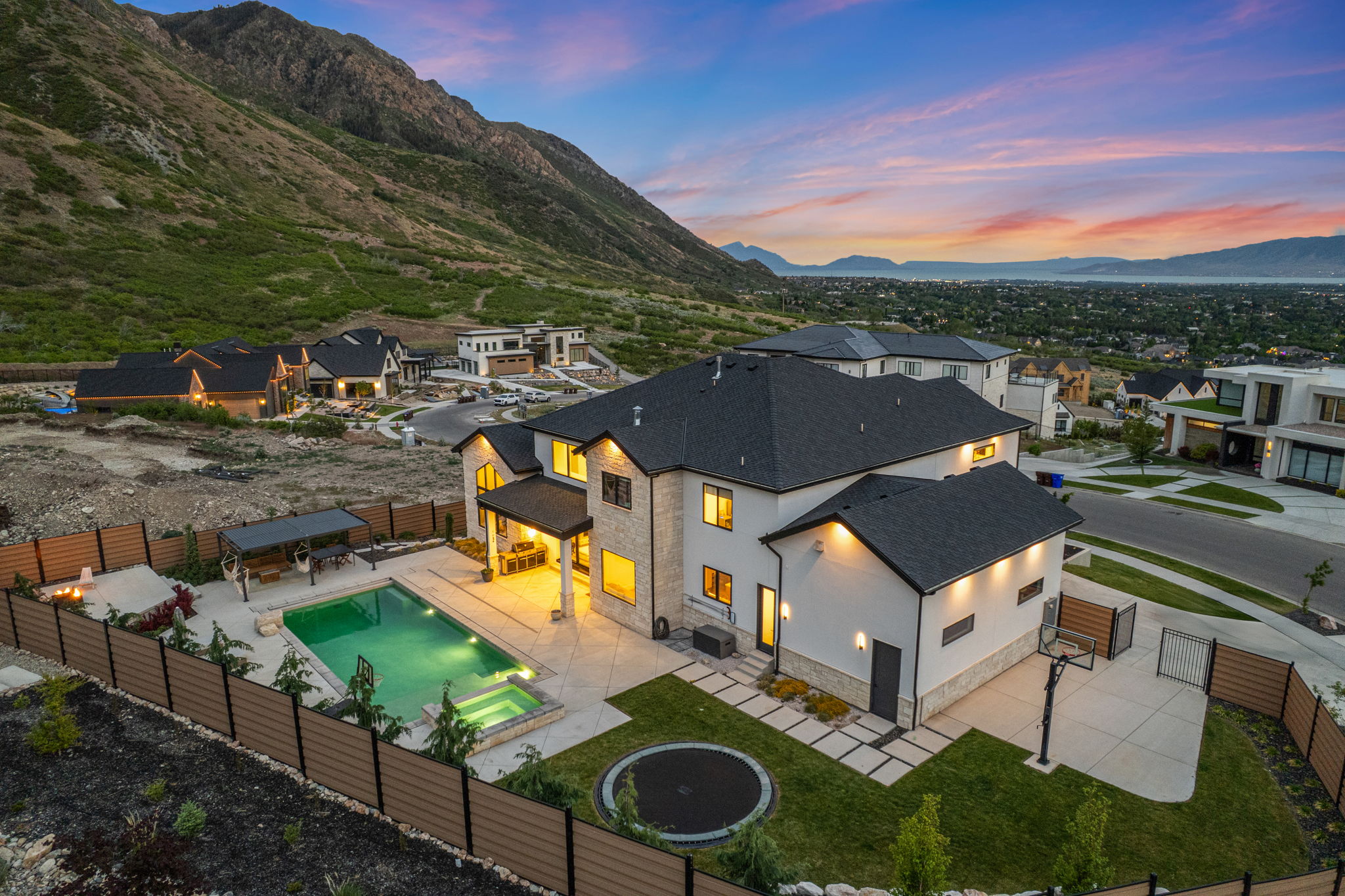 Contemporary stucco and stone exterior featuring a private backyard oasis with a swimming pool, integrated spa, and covered patio