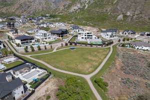 Expansive green space featuring a paved walking path, surrounded by contemporary residences