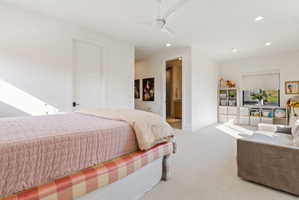 Spacious bedroom with light-colored carpet flooring and white walls