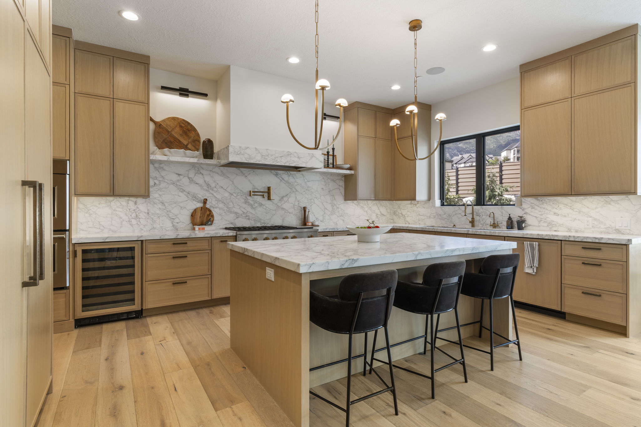 Gourmet kitchen with white oak cabinetry, Monogram appliances, and a built-white oak refrigerator