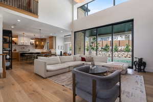 Spacious living area featuring high ceilings, wood-finish flooring, and expansive floor-to-ceiling windows