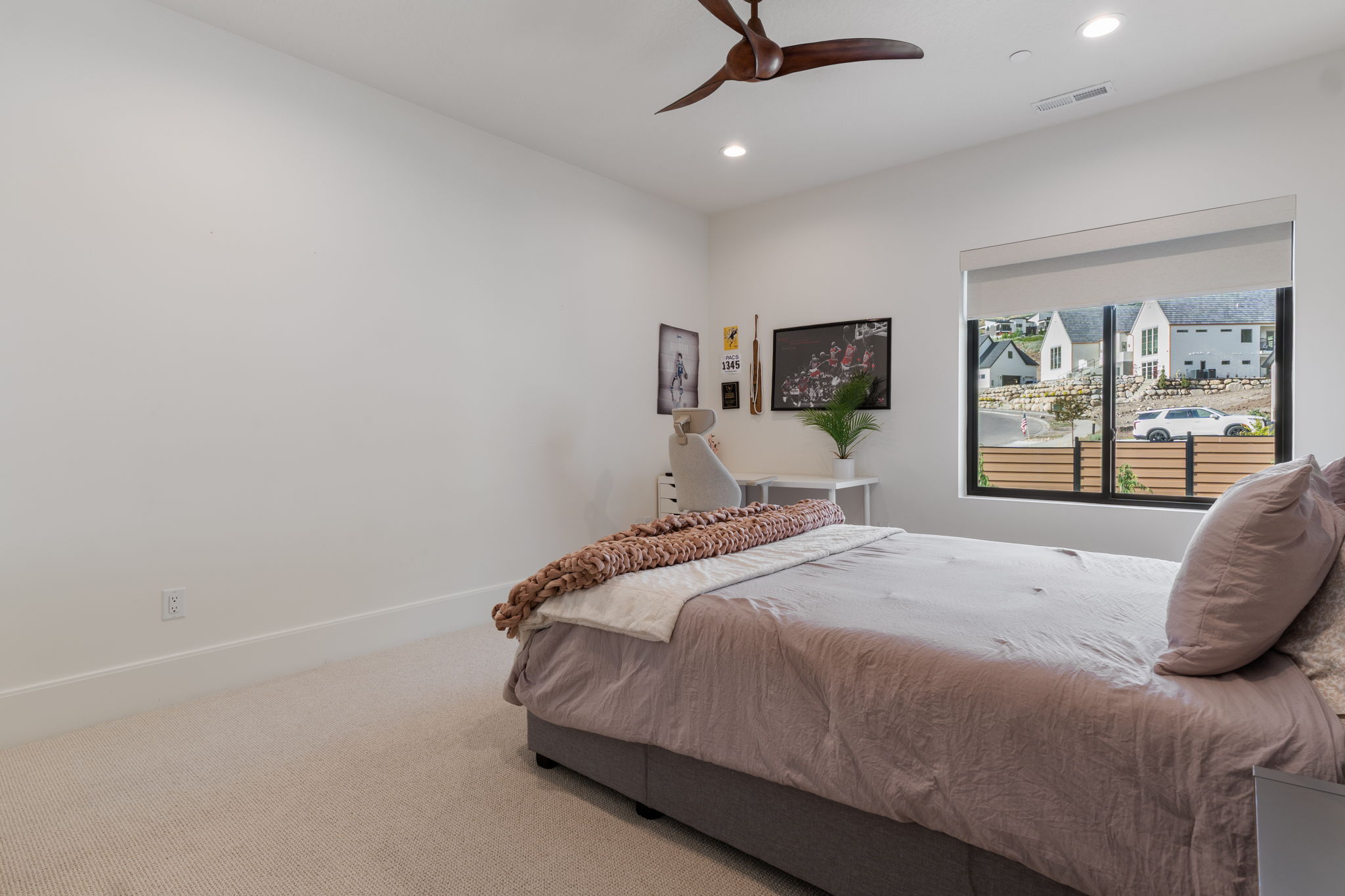 Bedroom featuring a large window with roller shade, recessed lighting, and a ceiling fan