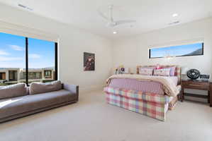Spacious room featuring broad windows with distant structures and mountain scenery, recessed lighting, and a ceiling fan