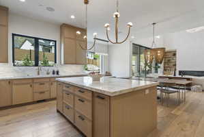 Kitchen island with a marble countertop and white oak cabinetry