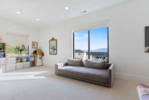Spacious room with large windows, recessed lighting, and light-colored carpeting
