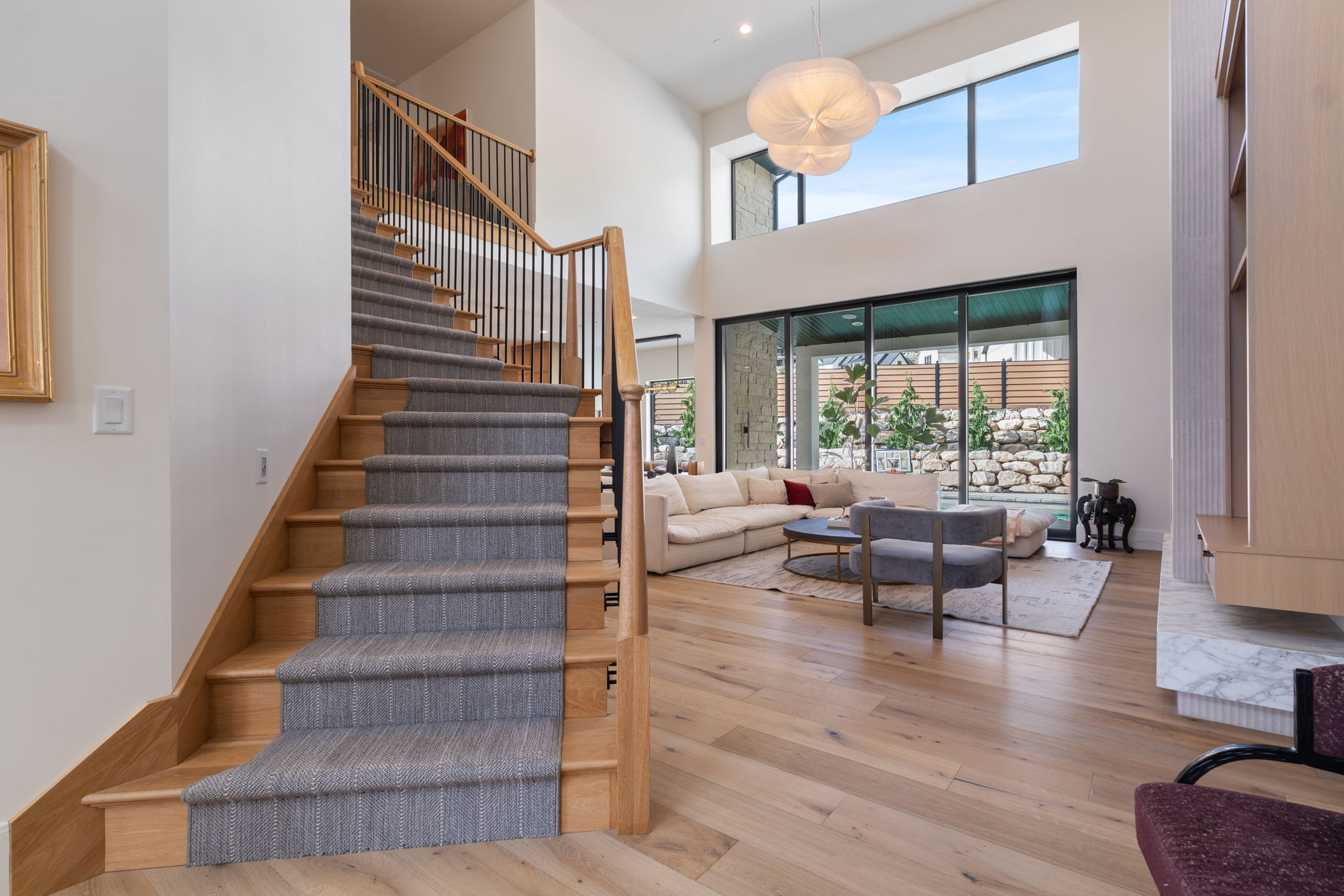 Grand staircase with wood treads and a gray runner