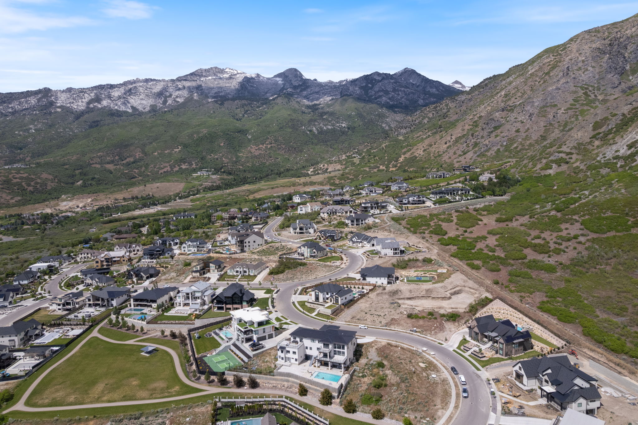 Residential community with varied architectural styles set against a mountainous backdrop
