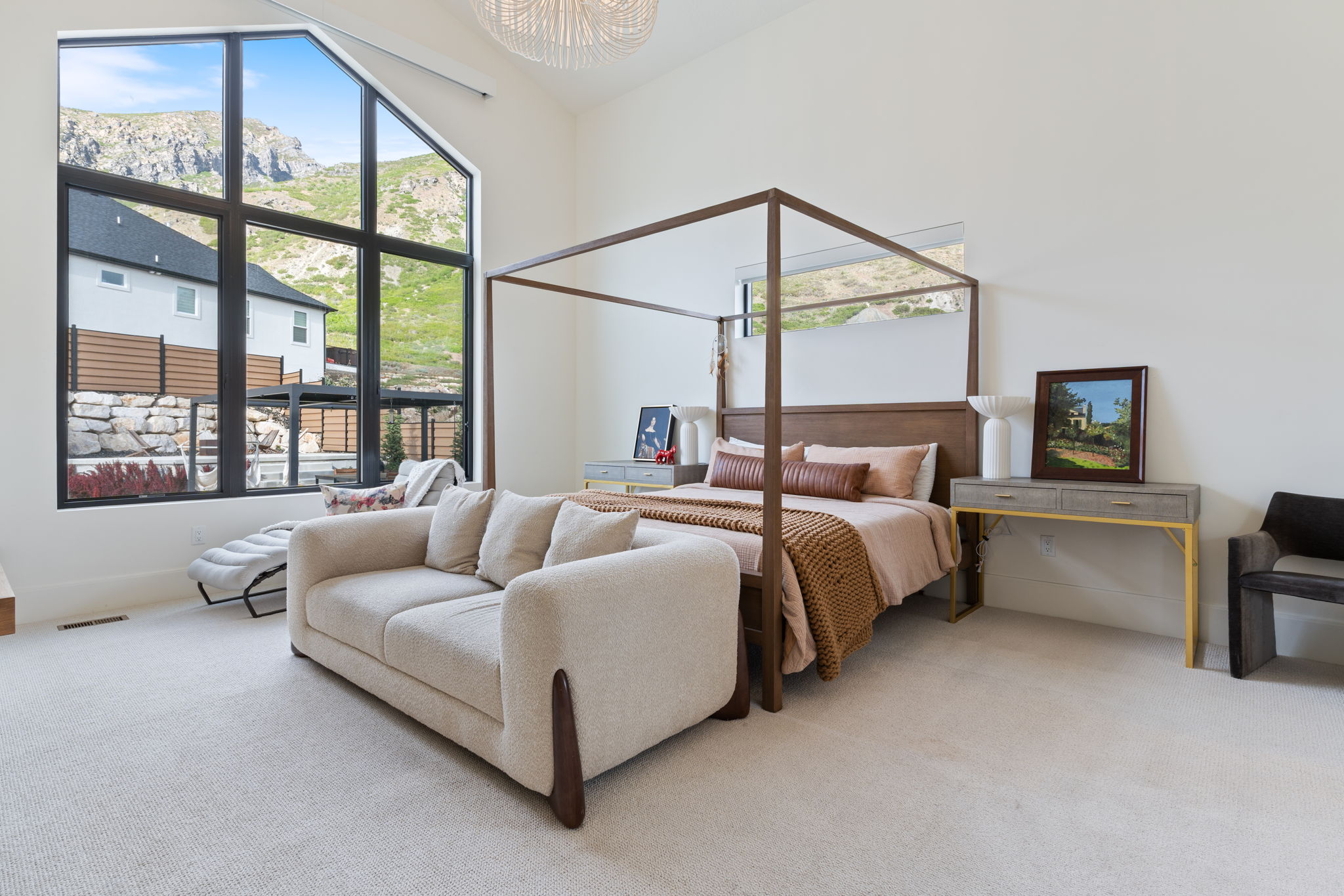 Expansive room featuring a vaulted ceiling and a large, multi-pane window framing a mountain backdrop