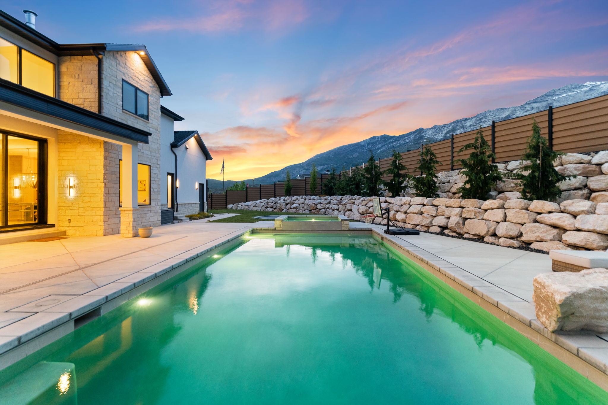 Outdoor swimming pool with integrated spa, bordered by a concrete patio